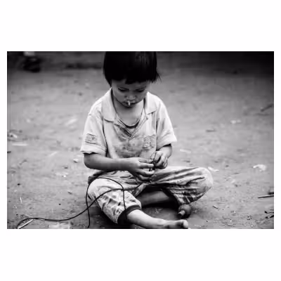enfant vietnamien jouant à la toupie sur la terre battue