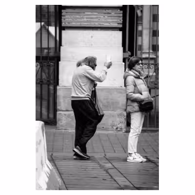 photographie d'un homme tenant un gobelet en carton dans la rue
