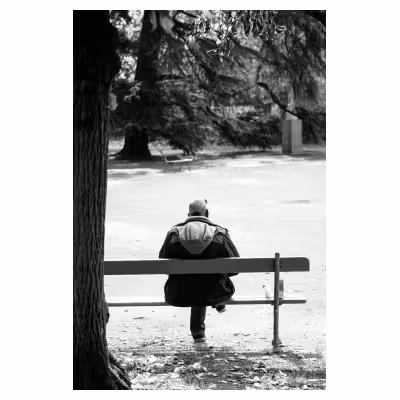 photographie de dos d'un homme assis sur un banc