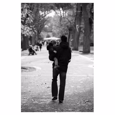 photographie d'un homme portant son enfant dans les bras