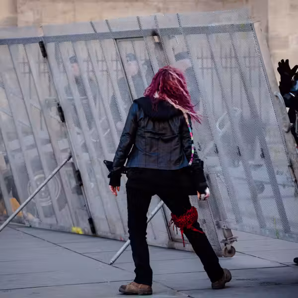 une manifestante semble danser devant un policier qui la salue de la main