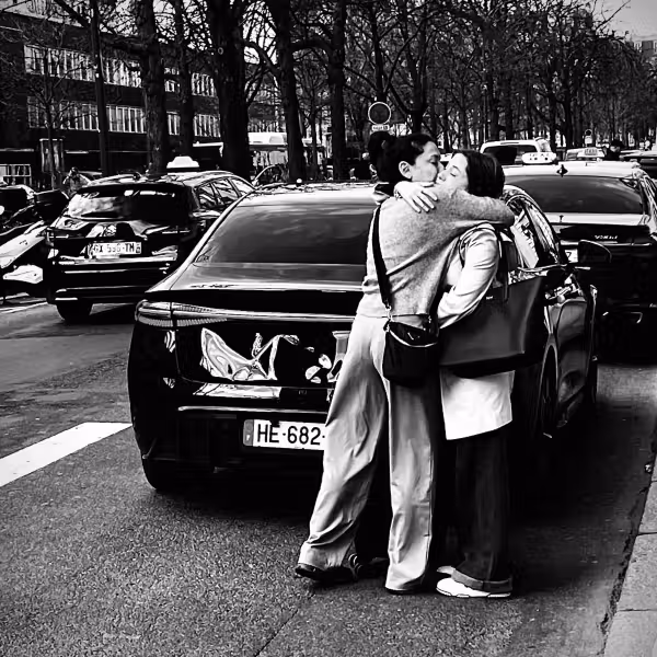 photographie en noir et blanc de deux femmes s'enlaçant tendrement dans la rue