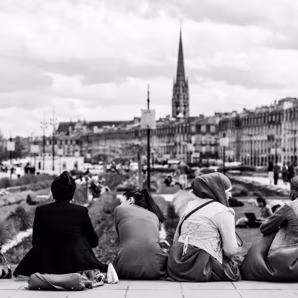 femmes musulmanes en train de discuter dans la rue avec un clocher d'église en arrière plan
